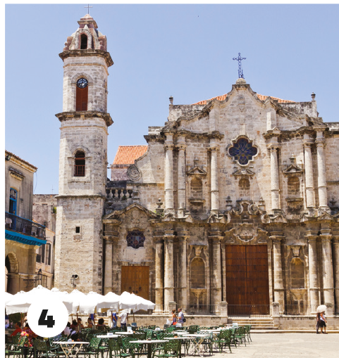 4. Square with a church in the background and café tables with umbrellas in the foreground. 